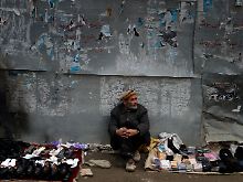 Ein Mann verkauft in Kabul Schuhe und Socken.
