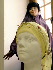 In einer Kopftuchausstellung werden die verschiedenen Modelle und die Aufgaben von Kopftüchern erklärt.