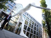 Die Figur vor der Münchener Zentrale scheint zu eilen: Die Mitarbeiter bewegen sich in der Regel gemesseneren Schrittes.