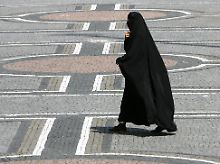 Eine Frau in einer Burka geht über den Odeonsplatz in München.