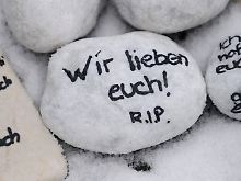 Bei der Gedenkfeier zum ersten Jahrestag des Amoklaufs liegen beschriebene Steine am Tatort.