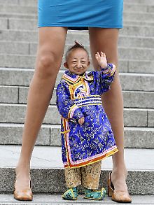 He Pingping zwischen den Beinen der Russin Svetlana Pankratova, der Frau mit den angeblich längsten Beinen der Welt, bei einem Foto für das Guinness-Buch der Rekorde 2009.