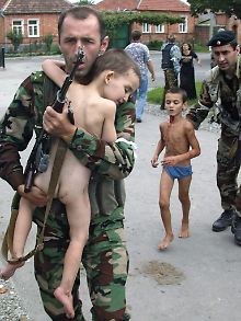 Ein russischer Soldat trägt einen Jungen, der lebend der Geiselnahme an einer Schule in Beslan im südrussischen Nordossetien entkommen ist. 