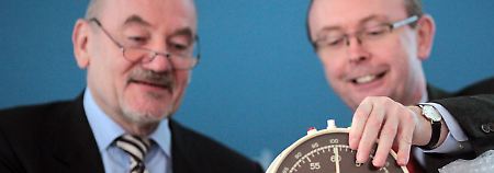 Die Zeit läuft: Der Präsident der Bundesnetzagentur (BNetzA), Matthias Kurth (l), und sein Pressesprecher Rudolf Boll packen eine Stoppuhr aus.