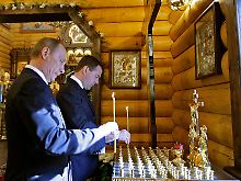 Der russische Präsident Medwedew und Ministerpräsident Putin zünden Kerzen für die Toten des Flugzeugunglücks an.
