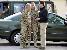 Guttenberg (r) spricht mit Generalinspekteur Wieker (l) und Brigadegeneral Leidenberger in Temes.