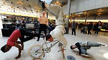 Mit Breakdance, Artistik auf einem BMX-Rad und Jonglage unterhalten Artisten des hannoverschen Varietes GOP die wartenden Passagiere auf dem Flughafen Hannover.