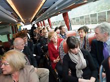 Merkel im Bus bei den mitreisenden Journalisten.