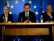 Finanzminister  Papakonstantinou lässt auf der Pressekonferenz in Madrid eine weitere scharze Katze aus dem Sack.