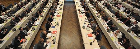 Die Verhandlungsdelegationen der Arbeitgeber (l) und Arbeitnehmer während der Gespräche in Würzburg.