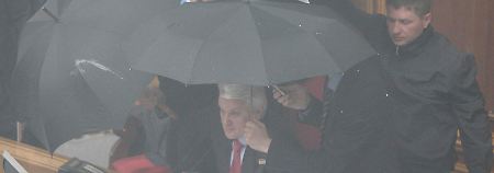 Litwin sucht Schutz unter Regenschirmen.