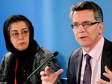 Innenminister Thomas de Maizière bei der Pressekonferenz. Neben ihm kommt die Theologin Hamideh Mohaghegi zu Wort.