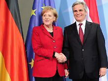 Merkel (CDU) und Faymann posieren nach der Pressekonferenz im Kanzleramt für die Medien.