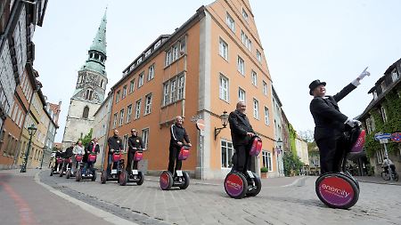 Der Vorstandschef der Stadtwerke Hannover, Feist (2.v.r.), und Schauspiel-Intendant  Walburg (3.v.r.) testen in der Innenstadt von Hannover eine Stadtführung auf Elektro-Rollern.