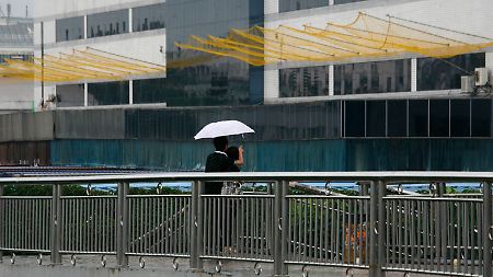 Ein Pärchen betrachtet die Auffangnetze am Foxconn-Gebäude in  Longhua in der Sonderwirtschaftszone Shenzhen. 