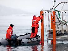 Forscher entnehmen Wasserproben aus dem eisigen Meer an der Nordwestküste von Spitzbergen.
