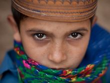 Ein pakistanischer Junge blickt neugierig in die Kamera eines Fotoreporters.