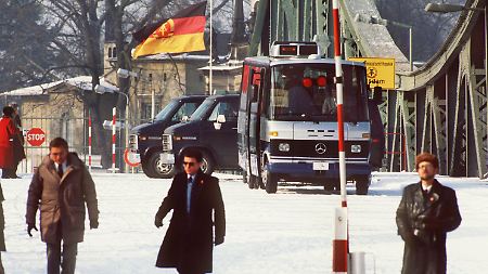 Sicherheitsbeamte in Zivil stehen 1986 bei dem dritten Agentenaustausch auf der Glienicker Brücke.