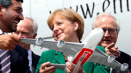 Nicht ohne Angela: Lachend überreicht Emirates-Chef Scheich Ahmed Bin Saeed Al Maktoum Kanzlerin Merkel ein Modell des Airbus A380. 