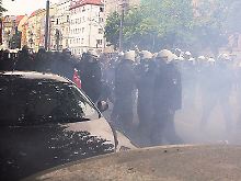 Polizisten stehen während der Demonstration gegen Sozialabbau nach der Explosion einer Bombe im Rauch.