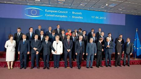 Gruppenbild. Der rote Punkt in der Mitte ist Angela Merkel.