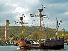 Einfahrt in den Hafen: Der Nachbau eines Hanseschiffes aus dem 15. Jahrhundert passiert den Leuchtturm von Travemünde.