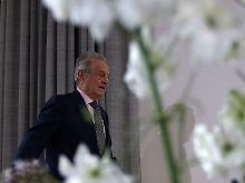 Hinter Blumen in der Humboldt-Uni: George Soros auf dem Weg zu Rednerpult und Regierungsattacke.