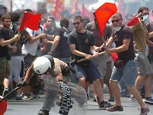 Athen: Demonstranten gehen gewaltsam gegen einen Polizisten vor.