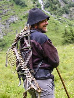 Michael Knollseisen, einer der Bertreuer der Bartgeier, macht sich mit dem Skelett eines Schafes auf den steilen Weg zur Futterstelle seiner Schützlinge.