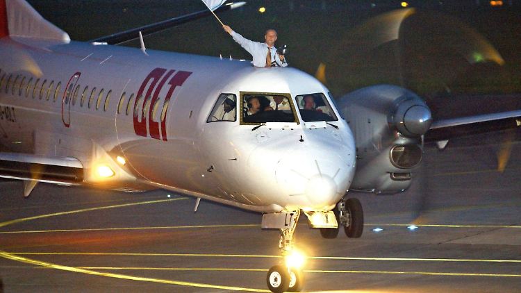 Deutscher Fußballmeister 2004: Nach der Landung in Bremen schwenkt Werder-Trainer Thomas Schaaf die Vereinsfarben aus der Dachluke einer Saab 2000.