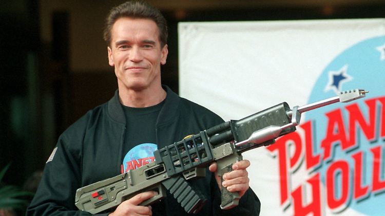 Arnold Schwarzenegger posiert mit der "Railgun" aus dem Actionfilm "Eraser".