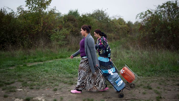 Zwei Roma-Frauen brinegn Wasser in ein Camp im Osten von Paris.