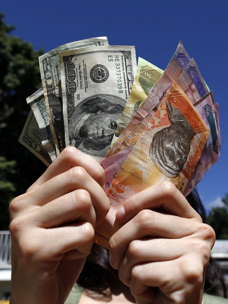 Dollar- und Bolivarnoten: Venezuela erschreckt mit einer deftigen Abwertung.