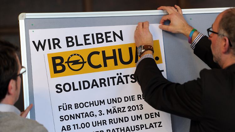 Opelaner hängen Plakate für das Opel Solidaritätsfest auf.