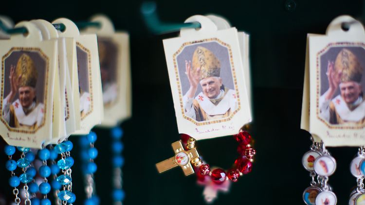 Auf dem Petersplatz in Rom werden Rosenkränze mit dem Bild von Papst Benedikt XVI. feilgeboten.