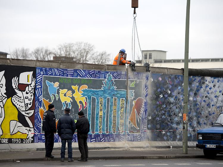 1. März: Ein Bauarbeiter befestigt einen Kranhaken an einem Mauerstück der East Side Gallery.