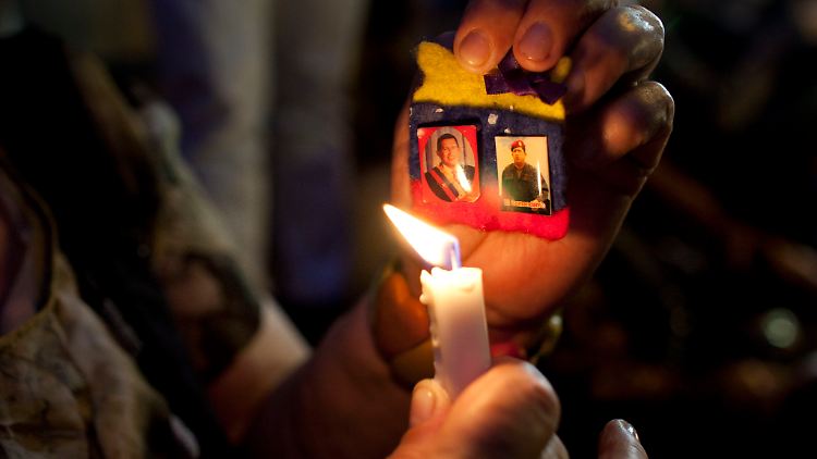 In Caracas beleuchtet eine Anhängerin von Hugo Chávez mit einer Kerze Bilder des Präsidenten. Auf der Nachtwache wurde für seine Genesung gebetet.