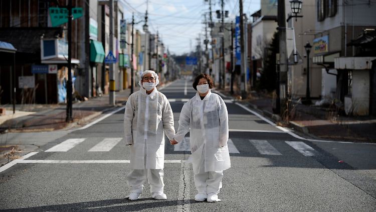 Die Stadt Namie in der Präfektur Fukushima ist weiterhin leer, die Einwohner dürfen nur für wenige Stunden zurückkehren. Sie tragen dann Schutzkleidung - wie dieses Ehepaar.
