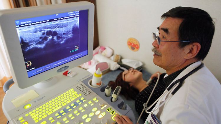 In der Präfektur Fukushima: Mit einem Ultraschall untersucht ein Arzt die Schilddrüse einer jungen Frau.