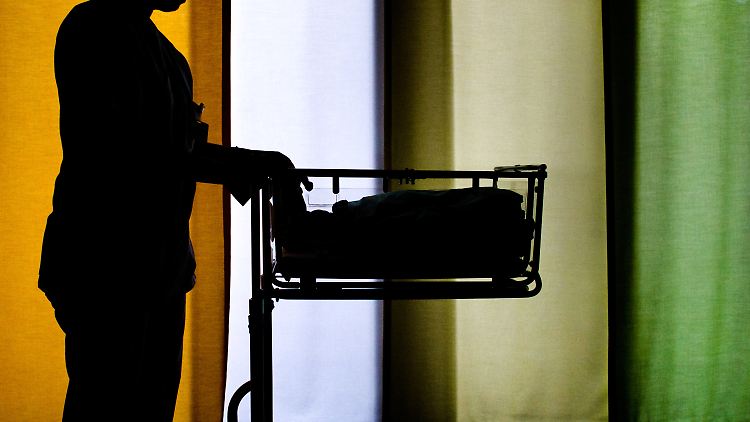 Frau an einem Säuglingsbett: Einer US-Studie zufolge erhöht Missbrauch in der Kindheit bei Frauen das Risiko, ein autistisches Kind zu bekommen.
