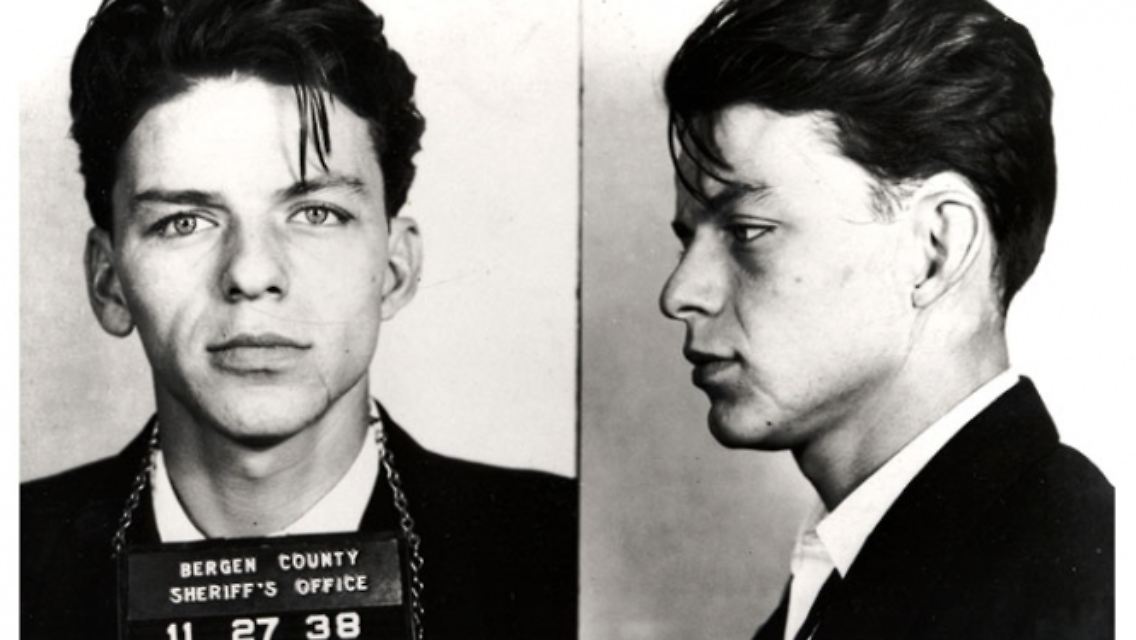Dieser schöne Jüngling heißt Frank Sinatra und ist auf einem Polizeirevier in New Jersey fotografiert worden - und zwar im Jahr 1938. Ihm wird damals eine Affäre mit einer verheirateten Frau zur Last gelegt. Das Verfahren wegen Ehebruchs wird später beigelegt.