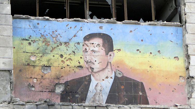 Ein Porträt des syrischen Präsidenten al-Assad an der Fassade einer zerstörten Polizeischule in Aleppo.
