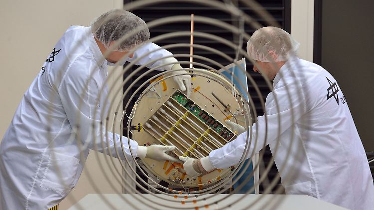 Raumfahrtingenieure arbeiten im Reinraum des DLR in Bremen am AI-Satellit.