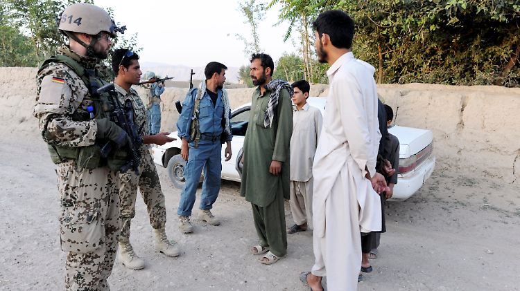 Bundeswehrsoldaten laufen nahe Kundus gemeinsam mit Polizisten der Afghanischen Nationalpolizei (ANP) Streife.