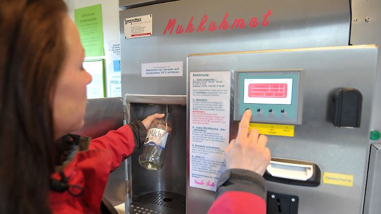 Eine Kundin zapft sich Milch am Muhkuhmat.