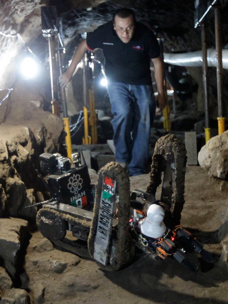 Ein Mitarbeiter des Nationalen Institutes für Anthropologie und Geschichte neben dem Roboter Tlaloc II an der archäologischen Stätte in Teotihuacan.
