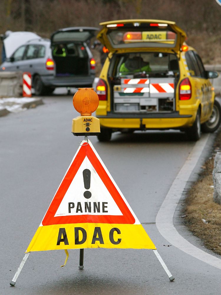 Ein ADAC-Warnschild sichert ein Auto, das mit einer Panne liegen geblieben ist.