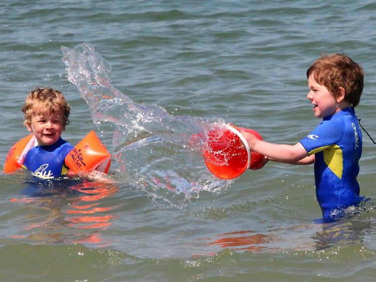 Wozu in die Ferne schweifen ... Kinder können bei den derzeitigen Temperaturen auch am Ostseestrand von Warnemünde stundenlang im Wasser spielen.