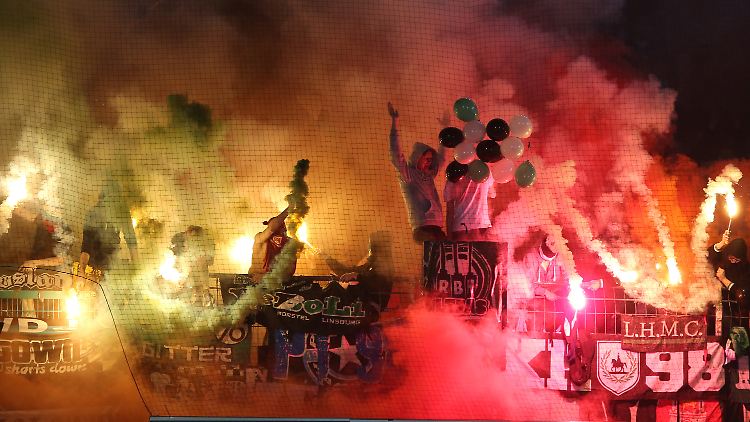 Fans von Hannover 96 zünden bengalische Feuer.