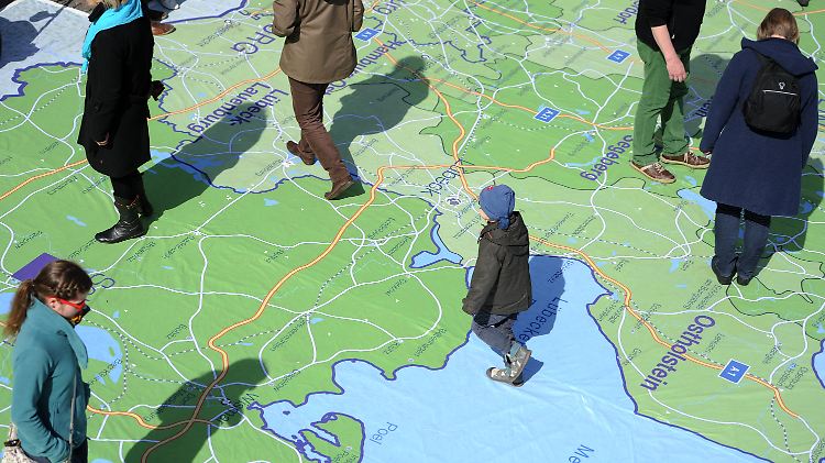 Passanten wandern am Rathausmarkt über eine Landkarte, die das Gebiet der Nordkirche zeigt.